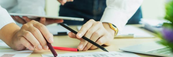 Two,Business,Colleagues,Standing,Around,Boardroom,Table,Having,Informal,Discussion